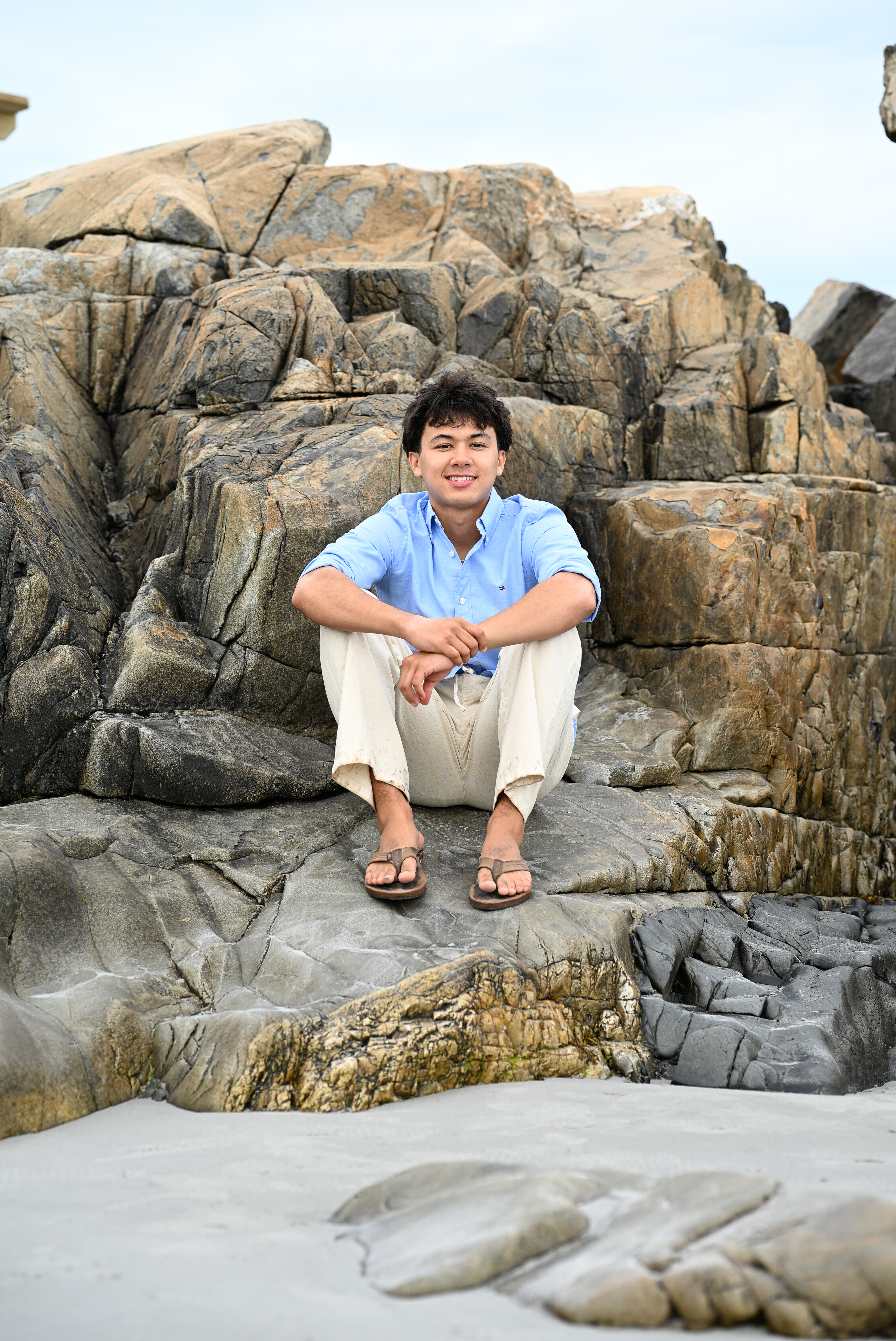 High school senior sitting on coastal rocks at Fort Foster, Kittery, Maine