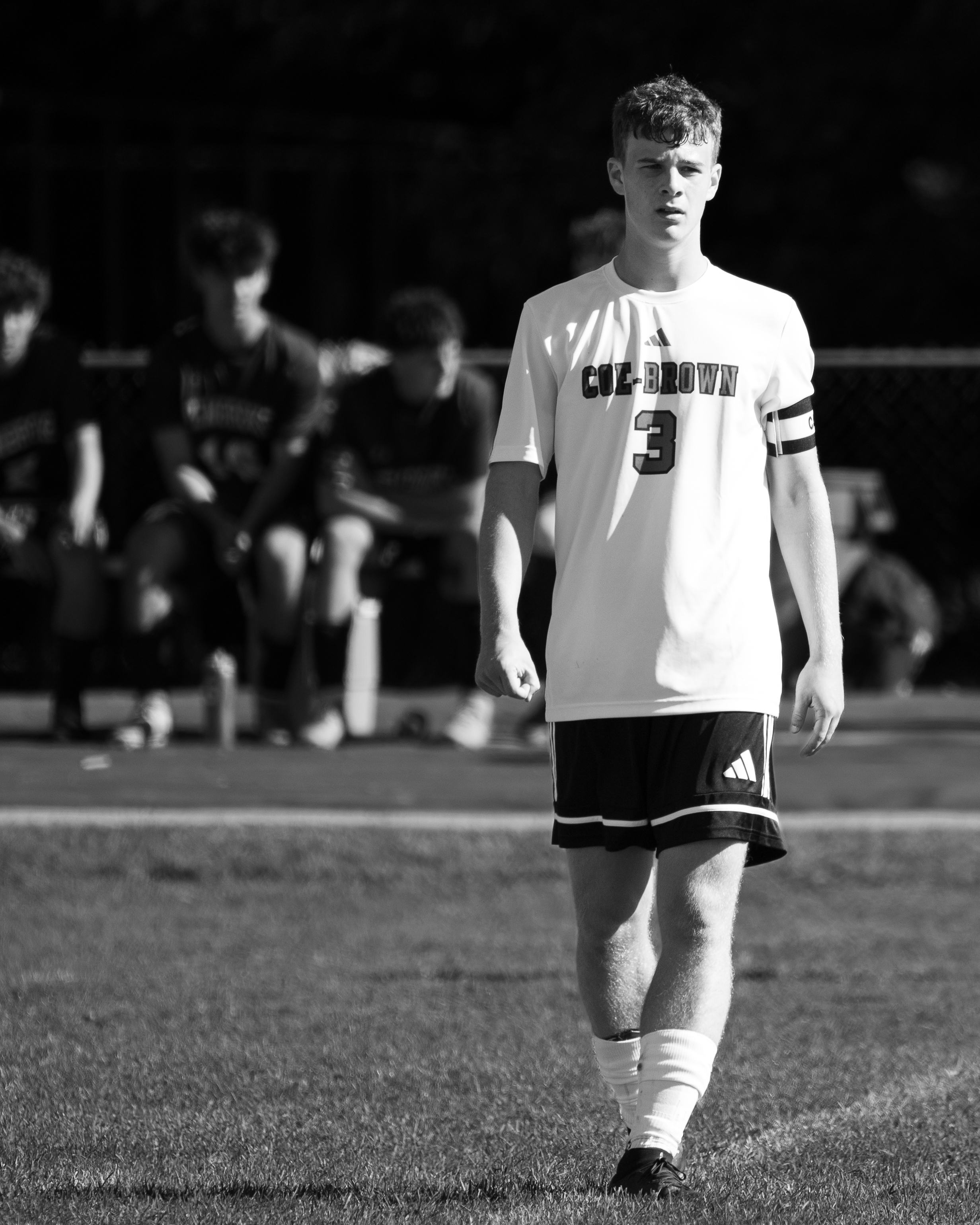 Coe-Brown soccer player walking off the field in black and white