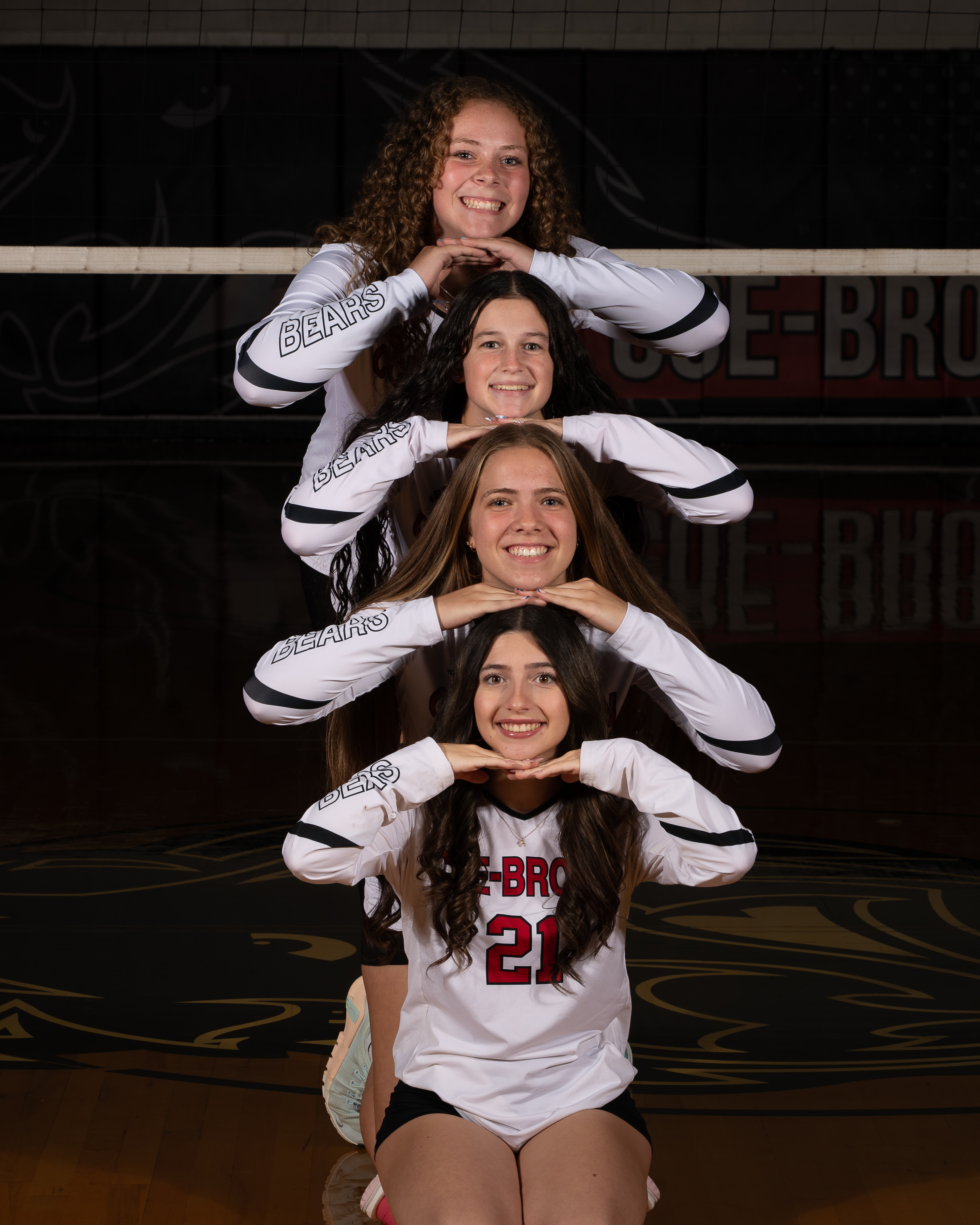 Coe-Brown volleyball players in a creative chin-stack pose