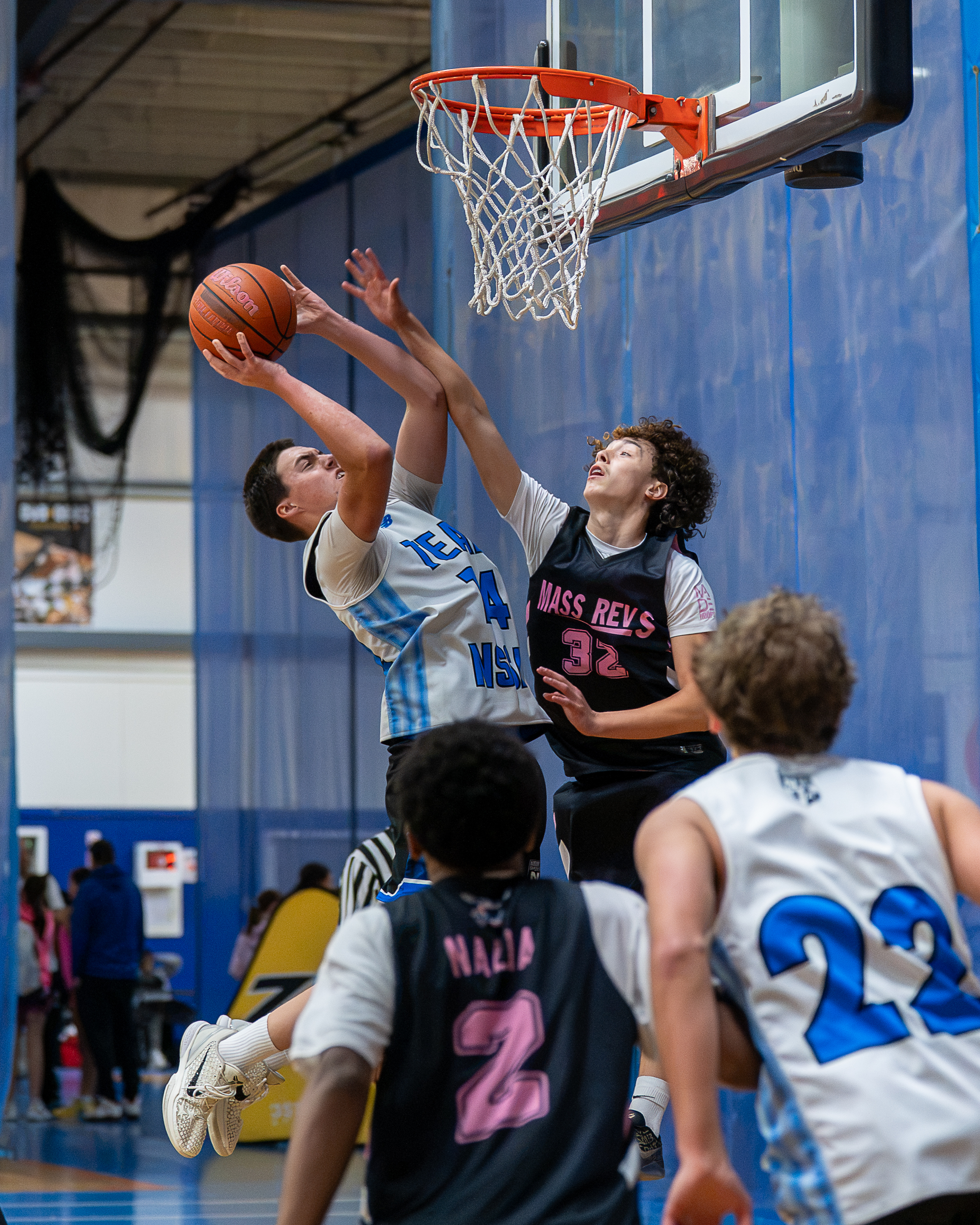 Contested layup between NSSA and Mass Revs players under the basket