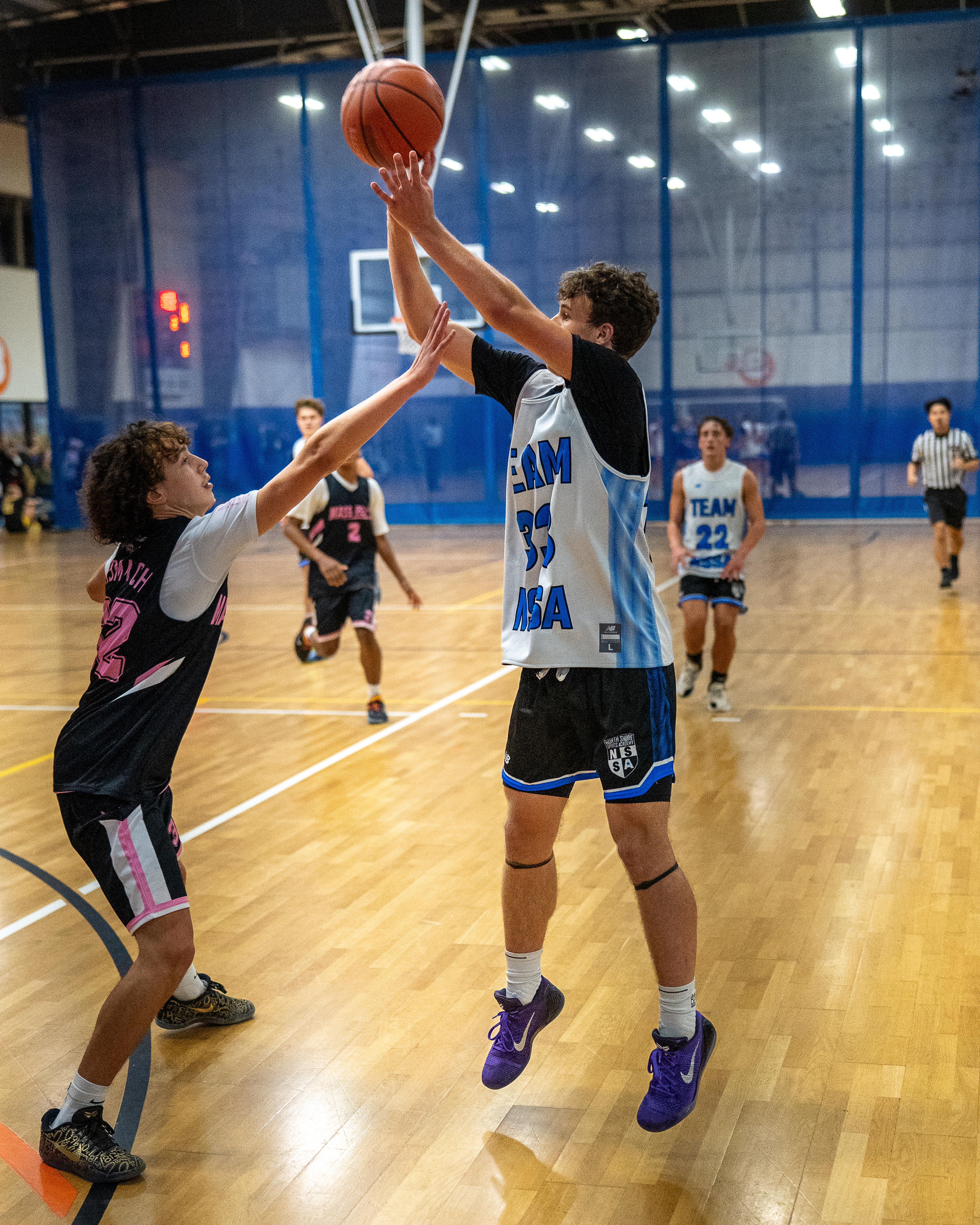 NSSA player shooting a jump shot over a Mass Revs defender