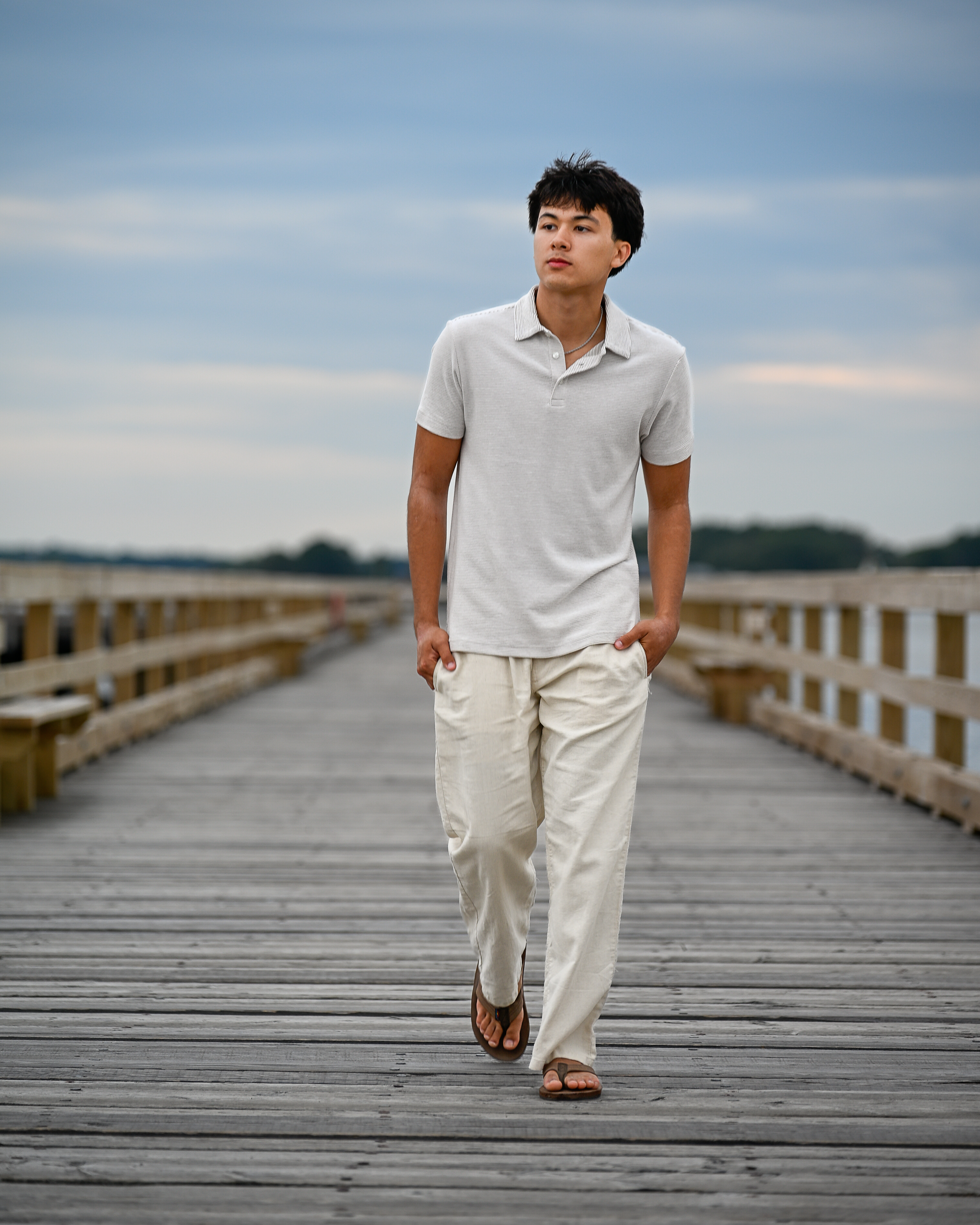 Senior portrait walking down the long pier at Fort Foster