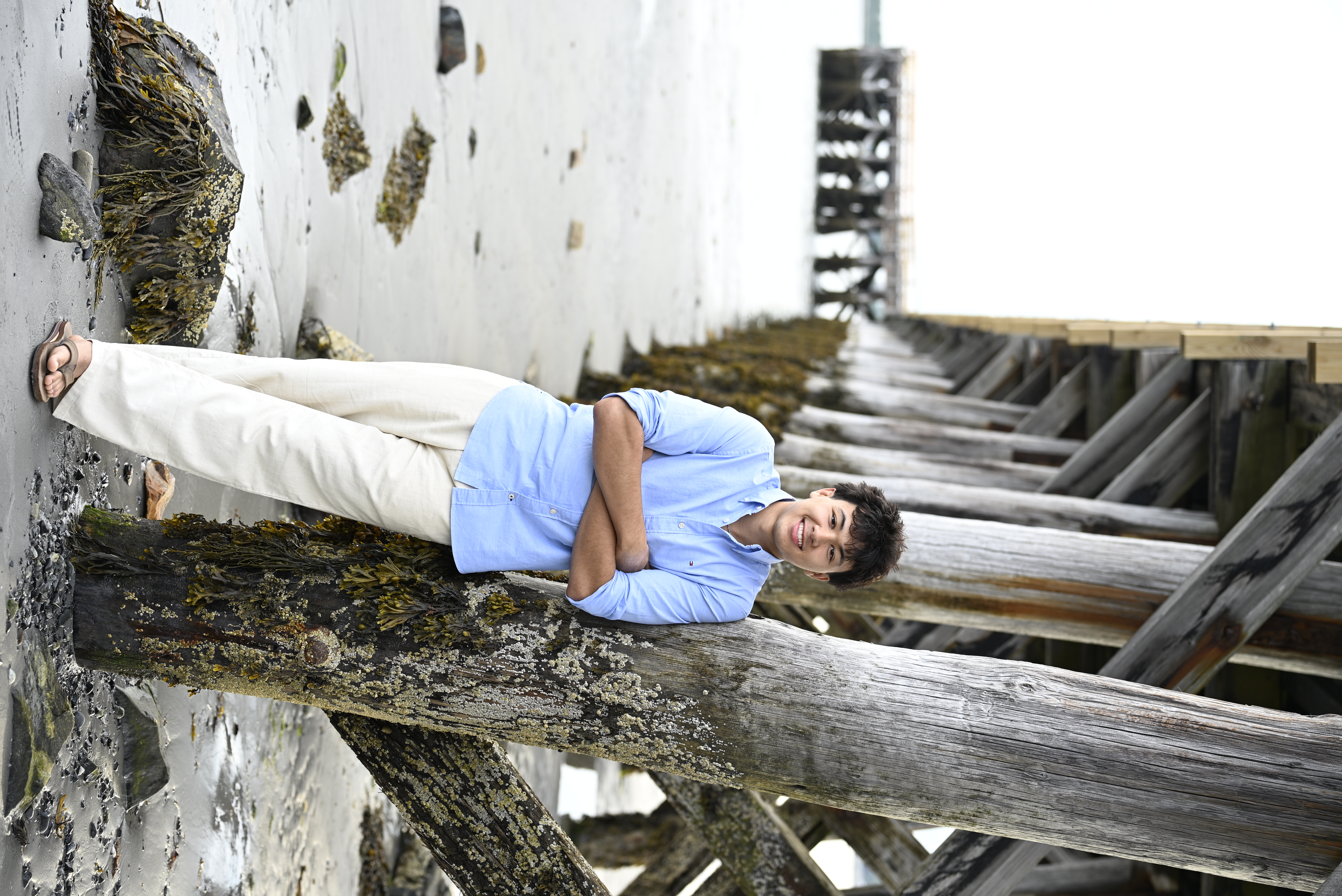 Senior portrait beneath a seaside pier